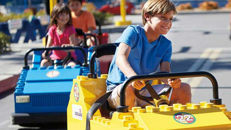 A group of children riding in a toy car  Description automatically generated